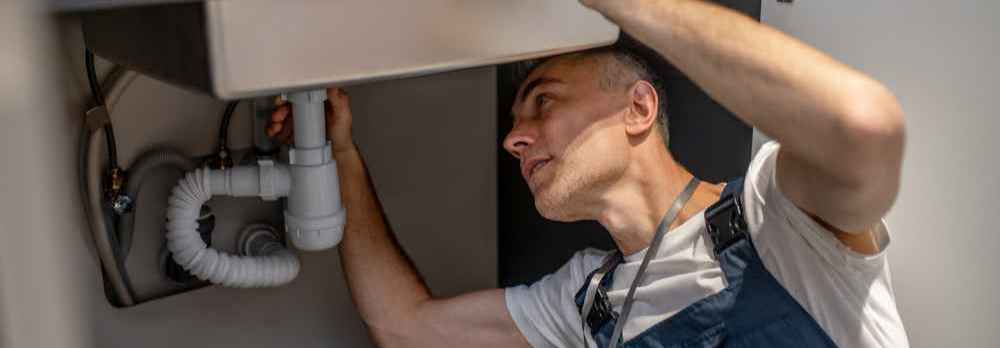 a plumber inspects the new pipe after repiping your home